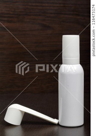 Inhaler for the treatment of respiratory organs. Spray can and cap white. On a dark surface. Inhaler for the treatment of respiratory organs. Spray can and cap white. On a dark surface. 116473174
