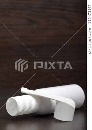 Inhaler for the treatment of respiratory organs. Spray can and cap white. On a dark surface. Inhaler for the treatment of respiratory organs. Spray can and cap white. On a dark surface. 116473175