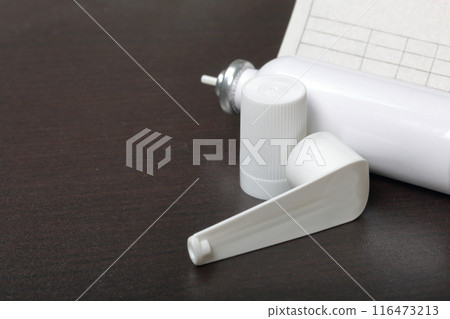 Inhaler for the treatment of respiratory organs. Spray can and cap white. Next recipe to buy. On a dark surface. Inhaler for the treatment of respiratory organs. Spray can and cap white. Next recipe to buy. On a dark surface. 116473213