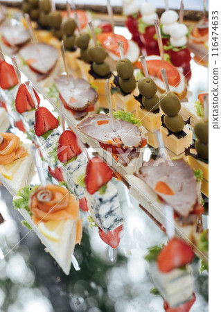 A large selection of various snacks for guests on a mirror surface. Buffet before an important event A large selection of various snacks for guests on a mirror surface. Buffet before an important event 116474633