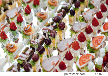 A large selection of various snacks for guests on a mirror surface. Buffet before an important event A large selection of various snacks for guests on a mirror surface. Buffet before an important event 116474639
