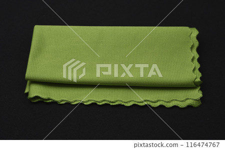 A green cleaning cloth on a black background. A green cleaning cloth on a black background. 116474767