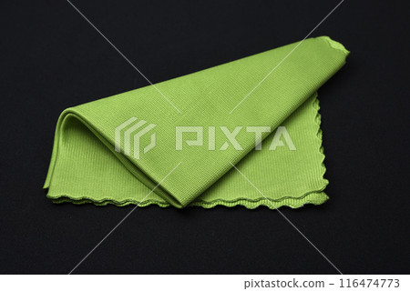 A green cleaning cloth on a black background. A green cleaning cloth on a black background. 116474773