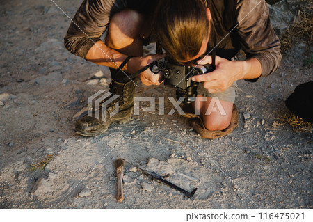 Historical reconstruction of an archaeological expedition of the mid-19th century. Concept for a history channel. An archaeologist takes a photo of a found artifact Historical reconstruction of an archaeological expedition of the mid-19th century. Concept for a history channel. An archaeologist takes a photo of a found artifact 116475021