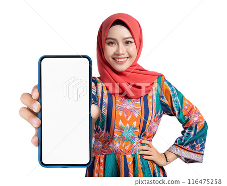 A smiling beautiful young Asian Muslim woman wearing hijab shows huge mobile phone 116475258