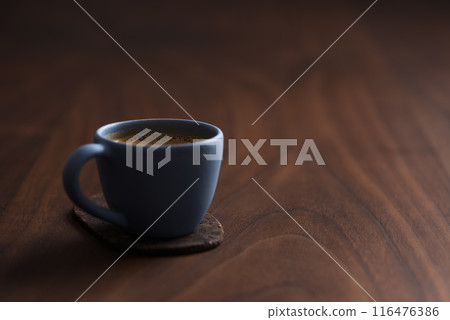 Fresh espresso in a blue cup on walnut table with copy space 116476386