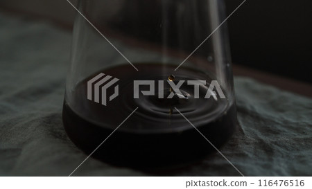 pour over coffee dripping in glass carafe on table with linen cloth pour over coffee dripping in glass carafe on table with linen cloth 116476516