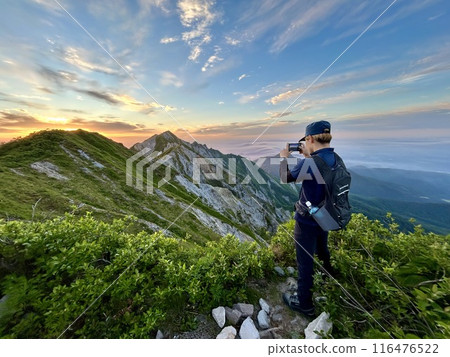 Man photographing the summit Man photographing the summit 116476522