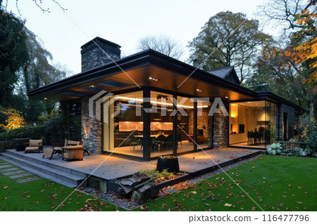 Modern house with extensive glass walls, surrounded by lush greenery. Modern house with extensive glass walls, surrounded by lush greenery. 116477796