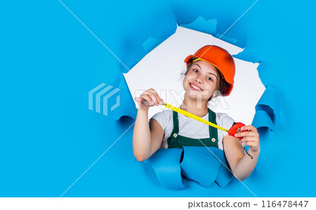 cheerful child laborer using building uniform and tape measure, copy space, labor day cheerful child laborer using building uniform and tape measure, copy space, labor day 116478447