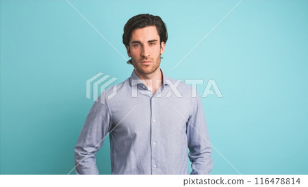 Serious man looking at camera in blue studio 116478814