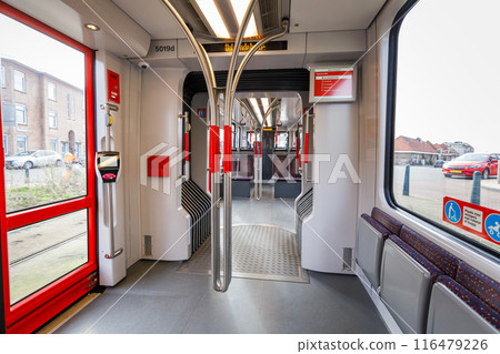 Interior of the empty Dutch tram, empty seats, white walls, big windows Interior of the empty Dutch tram, empty seats, white walls, big windows 116479226