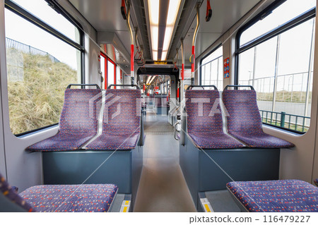 Interior of the empty Dutch tram, empty seats, white walls, big windows Interior of the empty Dutch tram, empty seats, white walls, big windows 116479227