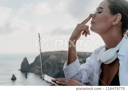 Woman sea laptop. Business woman, freelancer with laptop working over blue sea beach. Happy smiling girl relieves stress from work. Freelance, remote work on vacation, digital nomad, travel concept 116479770