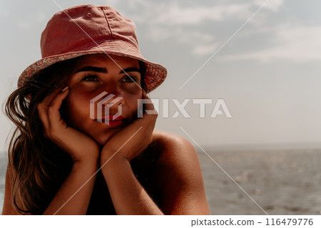 Happy young woman sunbathing or tanning on a seaside beach during summer vacation. smiling tourist in red swimsuit enjoying sun tan lying on beach near to calm clear sea water. Happy young woman sunbathing or tanning on a seaside beach during summer vacation. smiling tourist in red swimsuit enjoying sun tan lying on beach near to calm clear sea water. 116479776