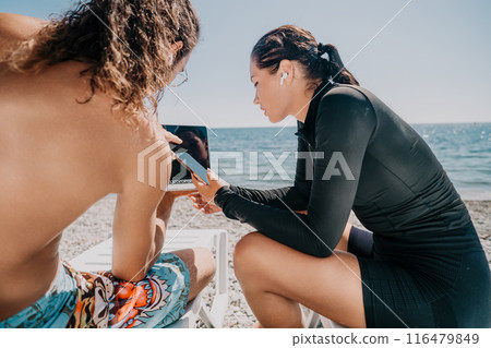 Man woman laptop sea. Working remotely on seashore. Happy successful couple, freelancers working on sea beach, relieves stress from work to restore life balance. Freelance, remote work on vacation 116479849