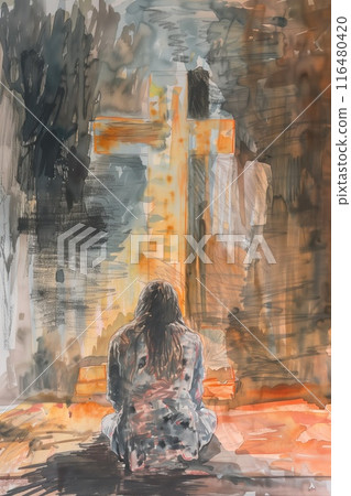 Figure sits on ground with gray shirt and black pants. Abstract painting in background features orange, brown cross against dark blue backdrop. Woman prays in front of cross. Devotion captured. 116480420