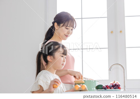 Girl helping mom cook Girl helping mom cook 116480514