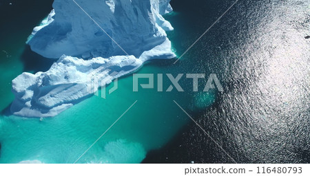 Massive iceberg melting, underwater ice formation floating turquoise ocean. Snow covered white and blue glacier under bright sun. Antarctica landscape. Global warming, climate change. Massive iceberg melting, underwater ice formation floating turquoise ocean. Snow covered white and blue glacier under bright sun. Antarctica landscape. Global warming, climate change. 116480793