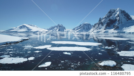 Antarctica ocean bay aerial landscape in sunny day. Melting ice floe on water surface, blue sky, snow covered mountains in background. Antarctic travel exploration. Discover beauty of South Pole Antarctica ocean bay aerial landscape in sunny day. Melting ice floe on water surface, blue sky, snow covered mountains in background. Antarctic travel exploration. Discover beauty of South Pole 116480795