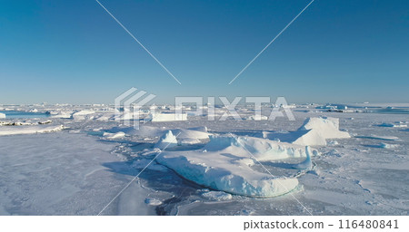 Winter Arctic landscape aerial panorama. Icebergs in frozen ice ocean under bright blue sky. Desert white land of snow and ice, South Pole. Pristine Antarctic scene. Antarctica travel and exploration Winter Arctic landscape aerial panorama. Icebergs in frozen ice ocean under bright blue sky. Desert white land of snow and ice, South Pole. Pristine Antarctic scene. Antarctica travel and exploration 116480841