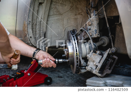 Mechanic man installing new brake disc and brake pads on car, car repair Mechanic man installing new brake disc and brake pads on car, car repair 116482509
