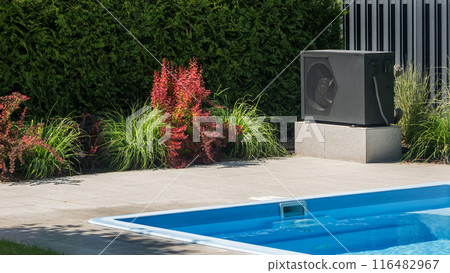 Outdoor heat pump near a swimming pool with surrounding decorative plants. 116482967