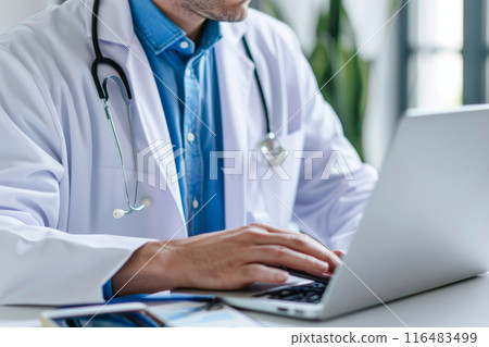Doctor working on a laptop in a modern office setting 116483499