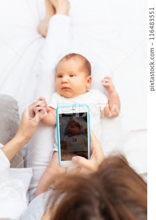 Mom Taking Photo of Newborn Baby with Smartphone.. Mom Taking Photo of Newborn Baby with Smartphone.. 116483551