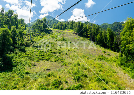Cable car seats soar over beautiful mountains on a sunny day in Krasnaya Polyana Cable car seats soar over beautiful mountains on a sunny day in Krasnaya Polyana 116483655