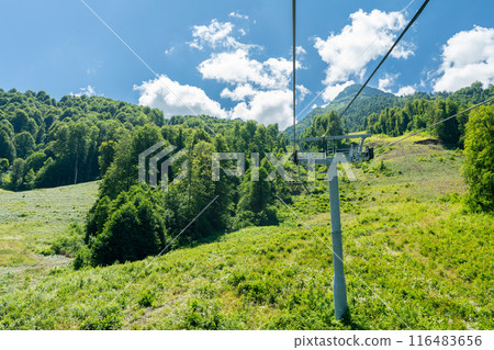 Cable car seats soar over beautiful mountains on a sunny day in Krasnaya Polyana Cable car seats soar over beautiful mountains on a sunny day in Krasnaya Polyana 116483656