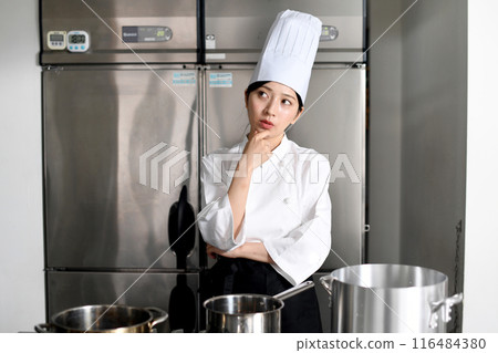 Young chef asian woman thinking in the kitchen 116484380