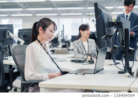 A pregnant woman doing desk work in the office 116484504