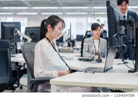 A pregnant woman doing desk work in the office A pregnant woman doing desk work in the office 116484506