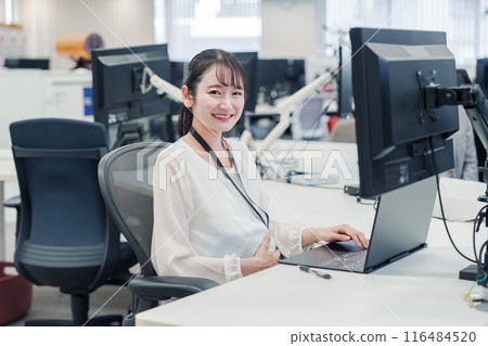 A pregnant woman doing desk work in the office A pregnant woman doing desk work in the office 116484520