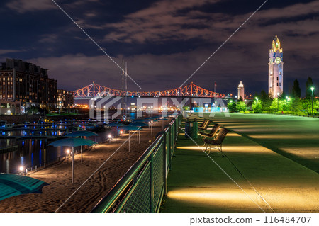 Old Port of Montreal Clock Tower and Jacques Cartier Bridge illuminated at night. Montreal, Quebec, Canada. 116484707