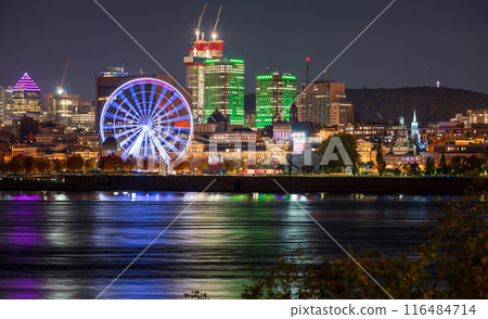 Old Port of Montreal and downtown skyline at night. Colorful buildings lights reflected in water. Montreal city, Quebec, Canada. 116484714