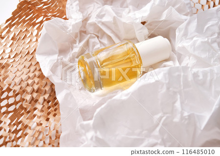 Bottle with yellow serum on paper from the parcel. Bottle with yellow serum on paper from the parcel. 116485010