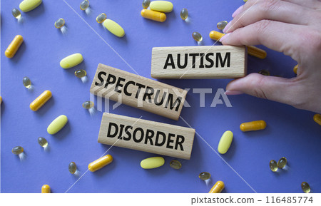 Autism Spectrum Disorder symbol. Concept word Autism Spectrum Disorder on wooden blocks. Doctor health. Beautiful purple background with pills. Medicine concept. Copy space 116485774