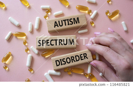 Autism Spectrum Disorder symbol. Concept word Autism Spectrum Disorder on wooden blocks. Doctor health. Beautiful pink background with pills. Medicine and Autism Spectrum Disorder concept. Copy space Autism Spectrum Disorder symbol. Concept word Autism Spectrum Disorder on wooden blocks. Doctor health. Beautiful pink background with pills. Medicine and Autism Spectrum Disorder concept. Copy space 116485821