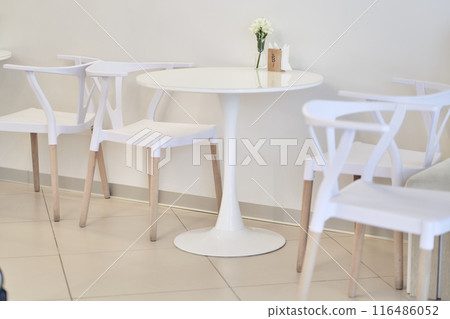There is a round white plastic table and chairs in the cafe. The table is made of plastic and has a round shape. There is a place to copy. High quality photo There is a round white plastic table and chairs in the cafe. The table is made of plastic and has a round shape. There is a place to copy. High quality photo 116486052