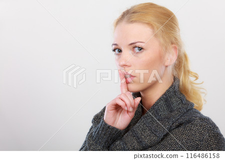 Woman holding finger close to lips, silence Woman holding finger close to lips, silence 116486158