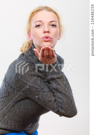 Flirty coquet blonde woman sending air kiss Flirty coquet blonde woman sending air kiss 116486159