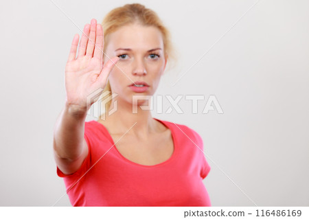 Woman showing stop gesture with open hand Woman showing stop gesture with open hand 116486169