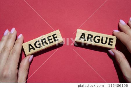 Agree or Argue symbol. Concept word Agree or Argue on wooden blocks. Businessman hand. Beautiful orange background. Gender and Agree or Argue concept. Copy space Agree or Argue symbol. Concept word Agree or Argue on wooden blocks. Businessman hand. Beautiful orange background. Gender and Agree or Argue concept. Copy space 116486196