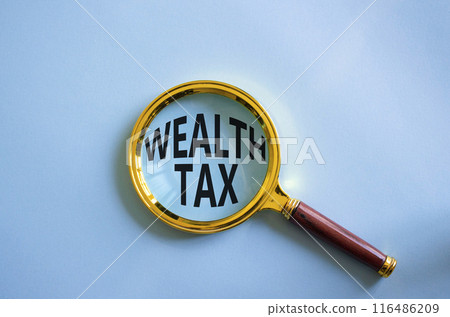 Wealth Tax symbol. Magnifying glass with words Wealth Tax. Beautiful blue background. Business and Wealth Tax concept. Copy space. 116486209