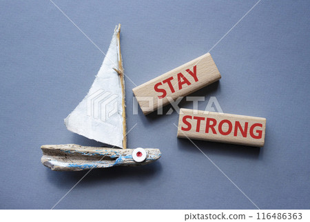 Stay Strong symbol. Concept word Stay Strong on wooden blocks. Beautiful grey background with boat. Business and Stay Strong concept. Copy space 116486363
