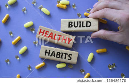 Healthy habits symbol. Concept word Build Healthy habits on wooden blocks. Doctor health. Beautiful purple background with pills. Healthy lifestyle and Healthy habits concept. Copy space Healthy habits symbol. Concept word Build Healthy habits on wooden blocks. Doctor health. Beautiful purple background with pills. Healthy lifestyle and Healthy habits concept. Copy space 116486378
