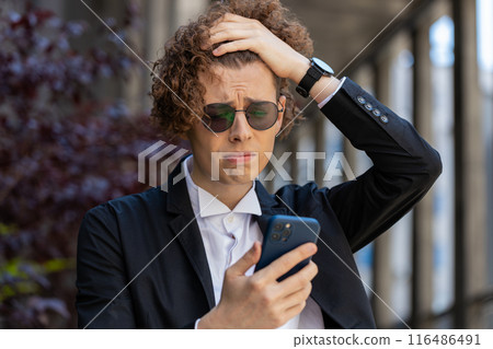 Shocked businessman using smartphone typing browsing, loses surprised by bad news fail bankruptcy Shocked businessman using smartphone typing browsing, loses surprised by bad news fail bankruptcy 116486491