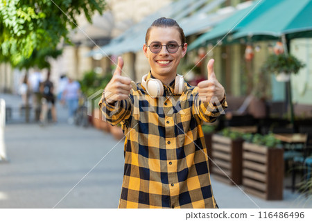 Happy man tourist showing thumbs up like sign gesture good positive feedback on urban city street 116486496